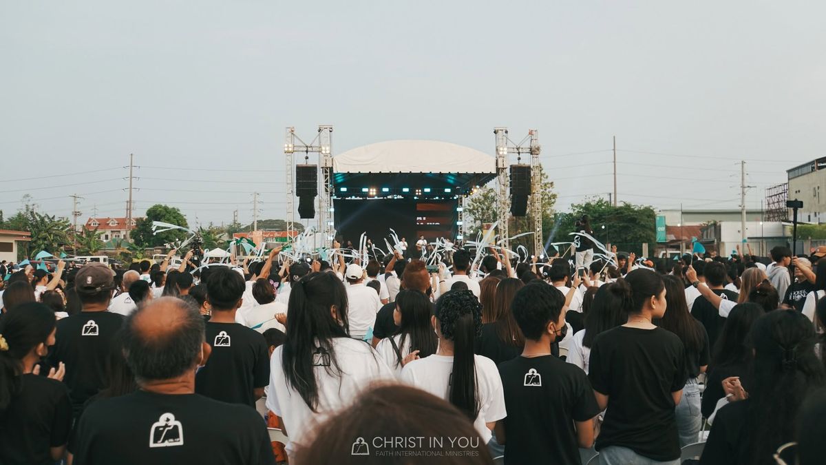 A large outdoor worship gathering of Christ In You Faith International Ministries